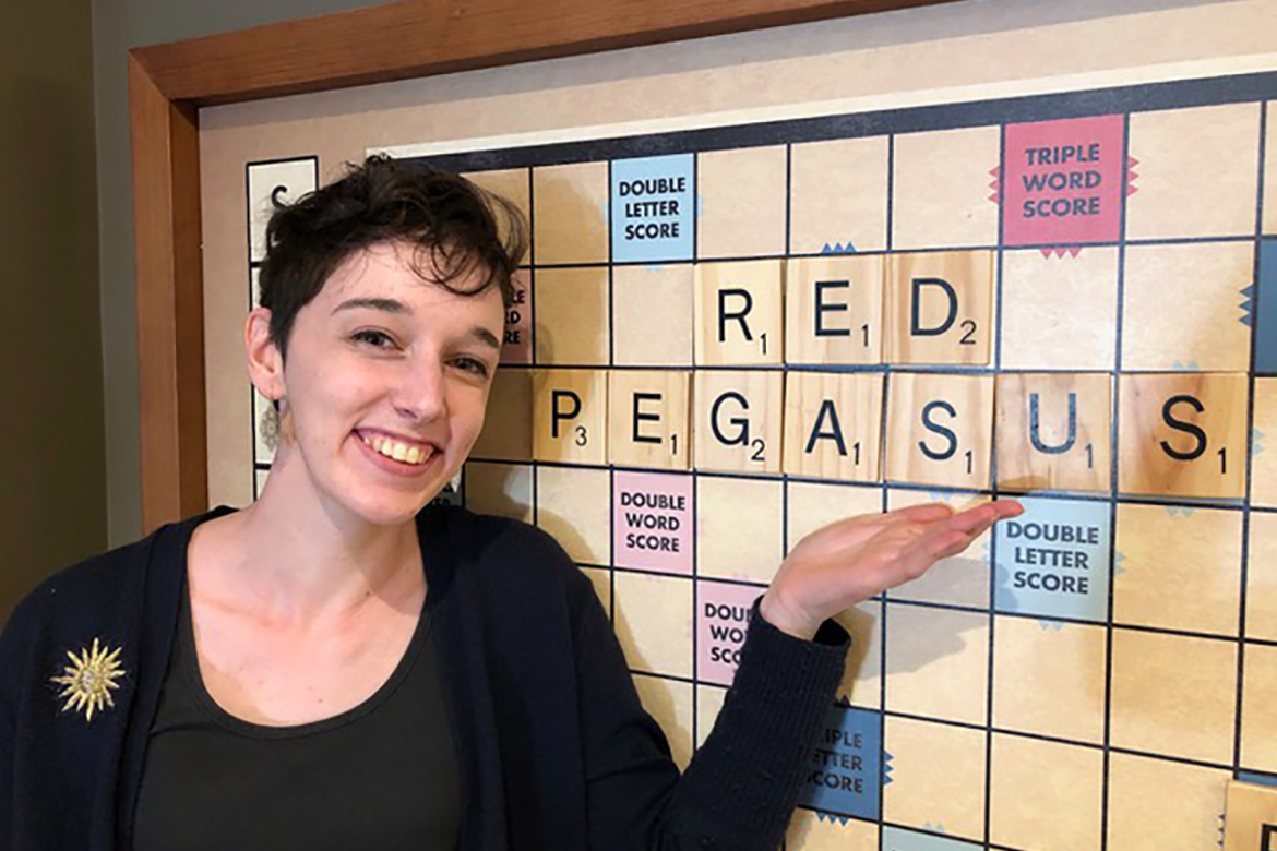 Sophia Smith displaying her red pegasus pride at the large Scrabble board in the Community Center
