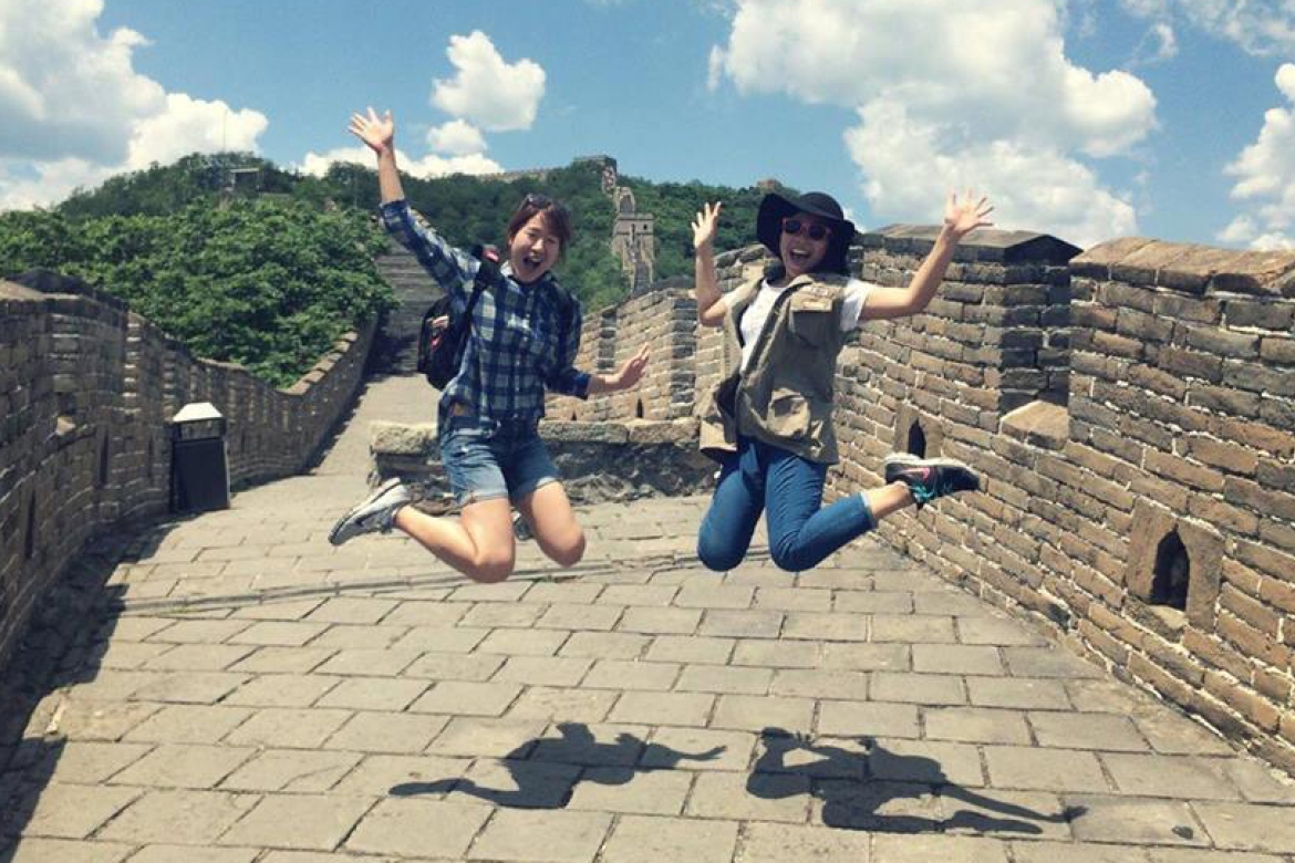 Phuong Nguyen ’17, on right, jumping for joy in front of the Great Wall of China.