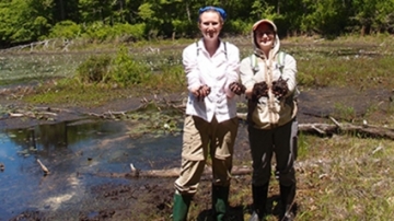 Photo of two students doing Tidmarsh research