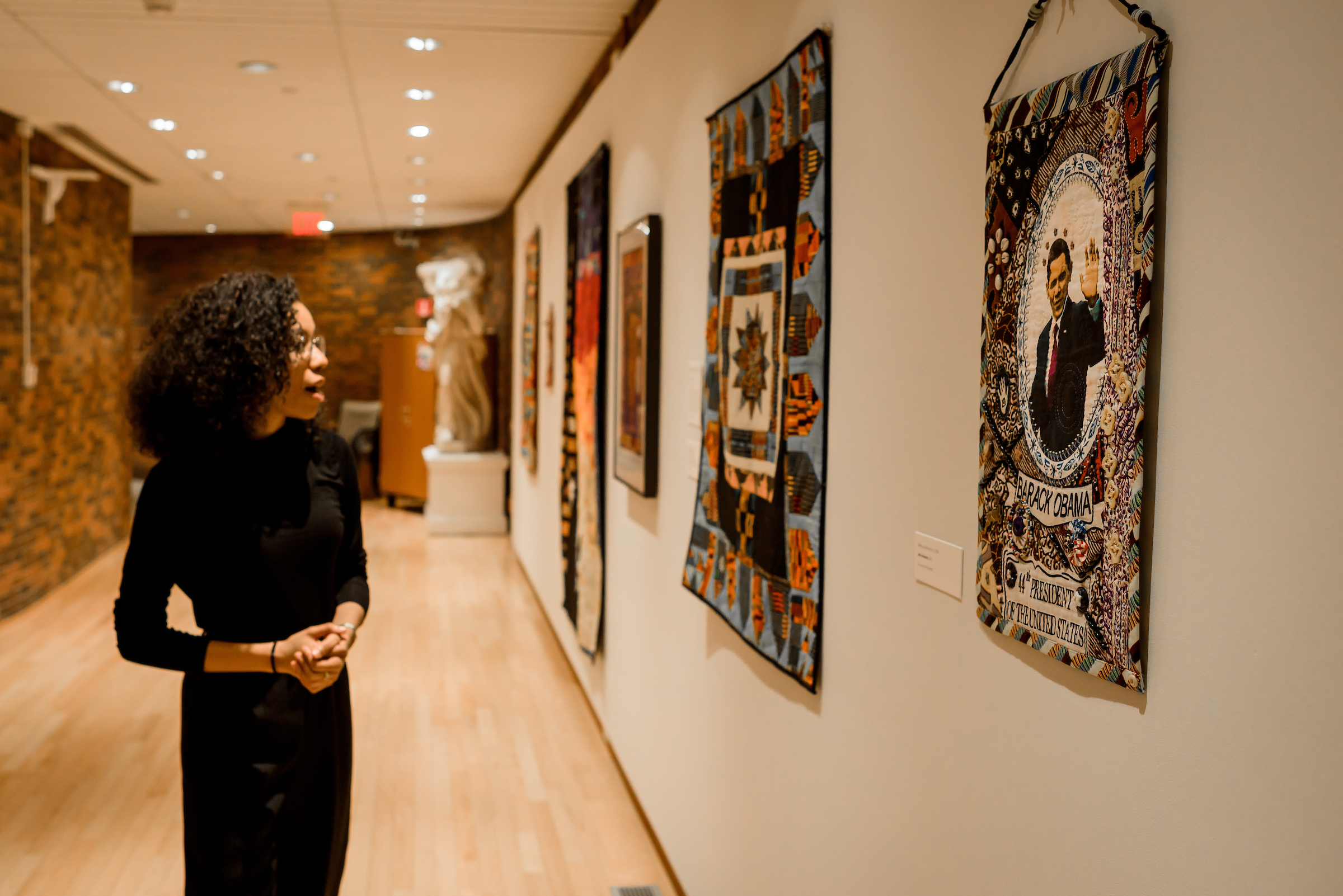 A student enjoying a wall of art in the art museum