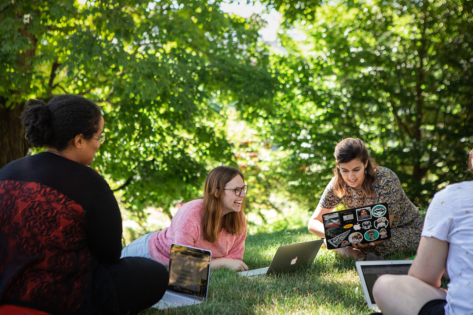 Professional and Graduate students outdoors in a discussion group.