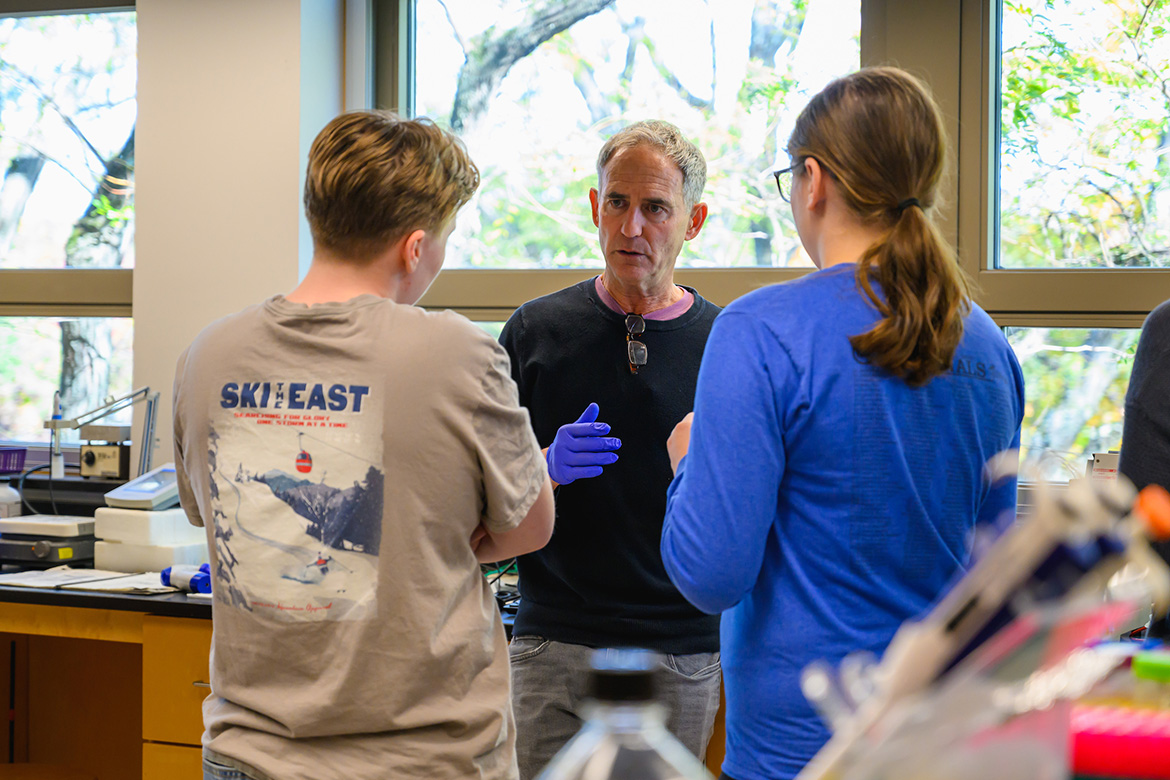 Craig Woodard in the Eukaryotic Molecular Genetics Lab with two students. Photo by Max Wilhelm.