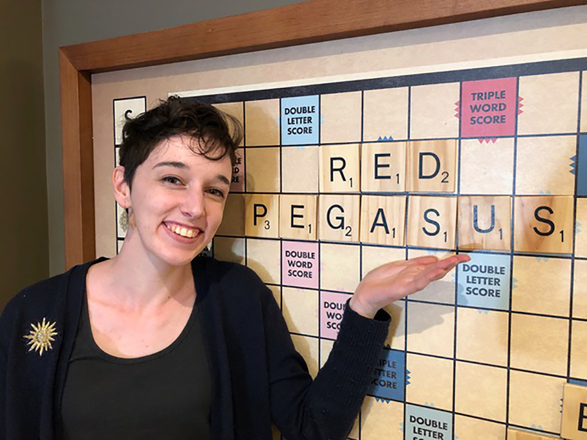 Sophia Smith displaying her red pegasus pride at the large Scrabble board in the Community Center