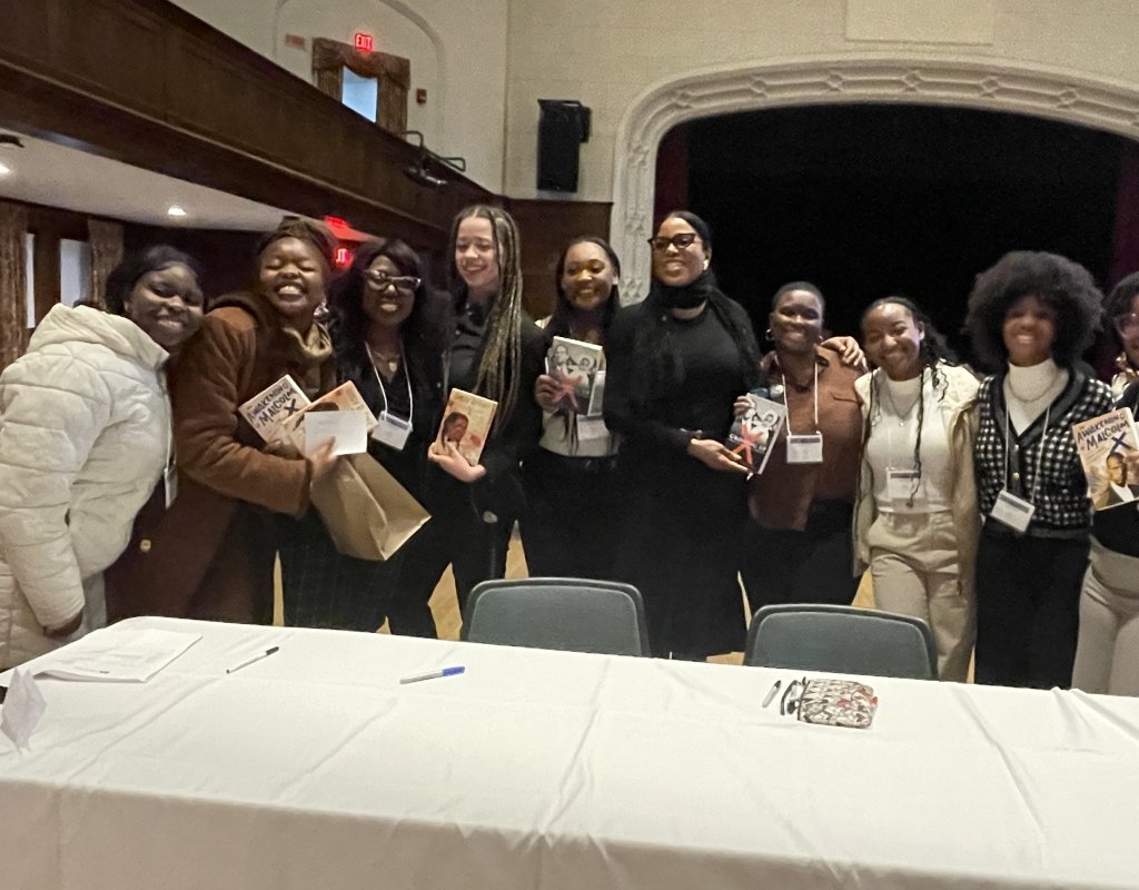 TOCLC attendees pose together with Ilyasah Shabazz and copies of her book.
