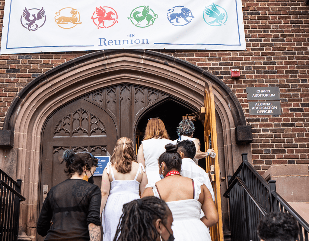Alums walking up the steps to go into Chapin Auditorium, underneath the Welcome Home banner