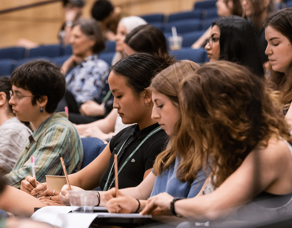 MWCE Climate Justice Summit audience taking notes.