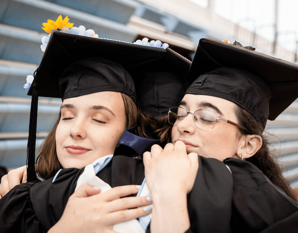 A three-way hug during Commencement 2023