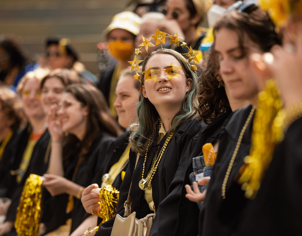 A group of seniors, one with star sunglasses and a star tiara, enjoying Convocation 2022