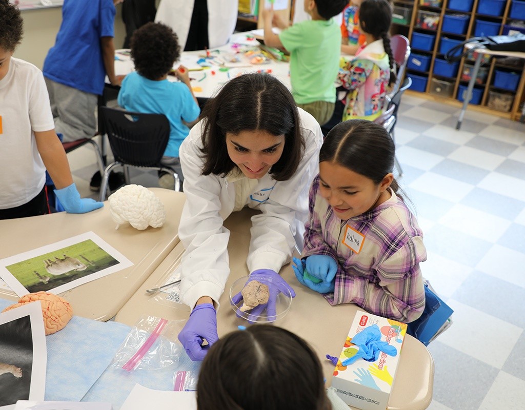 MHC Student engages with first graders during brain activity workshop.