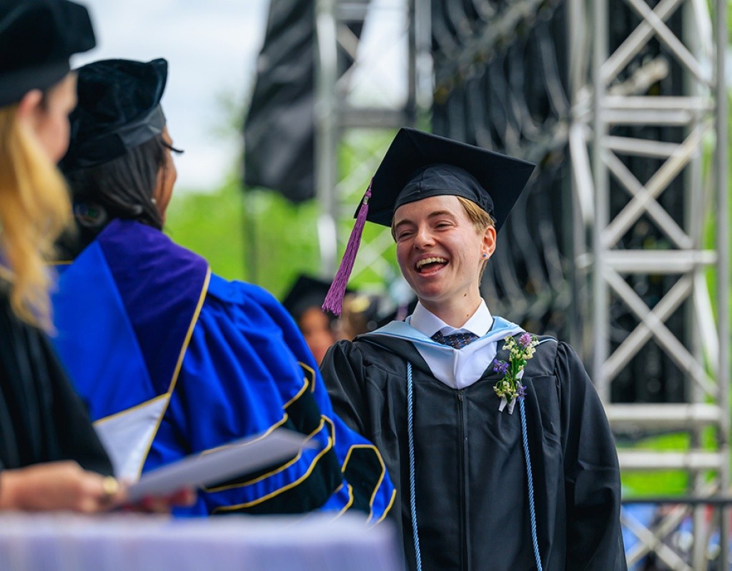 Student walks across the stage to collect their diploma.