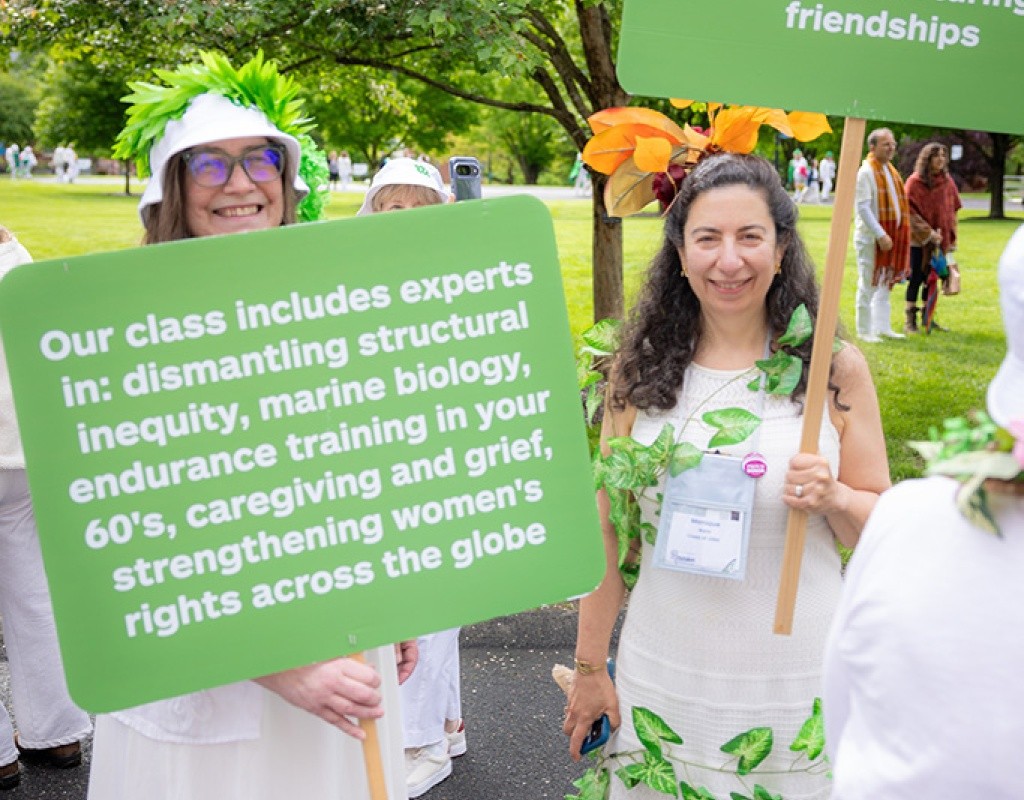 Alums hold green signs in the Laurel Parade at Mount Holyoke College, May 24, 2025
