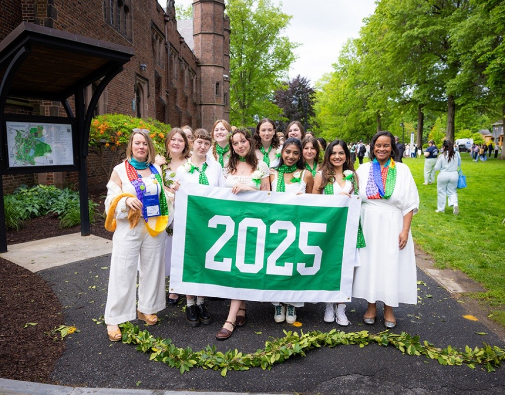Class of 2025 holding the class year sign before the Laurel Parade