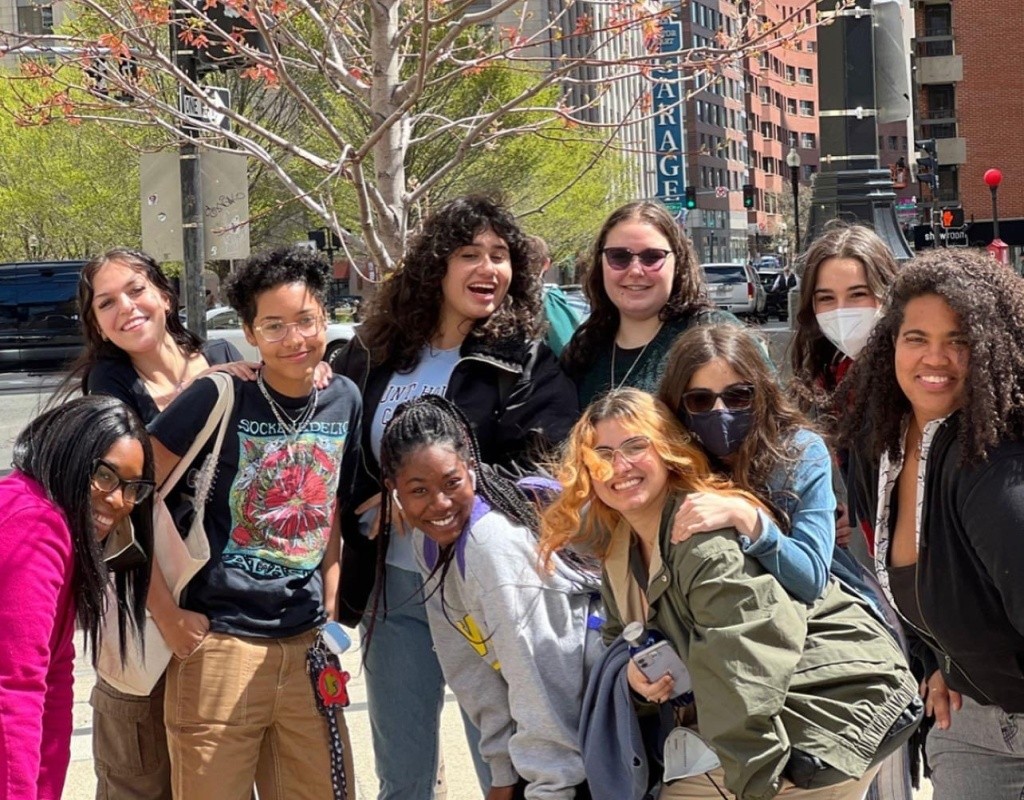 Posse Scholars posee together, a city view behind them.