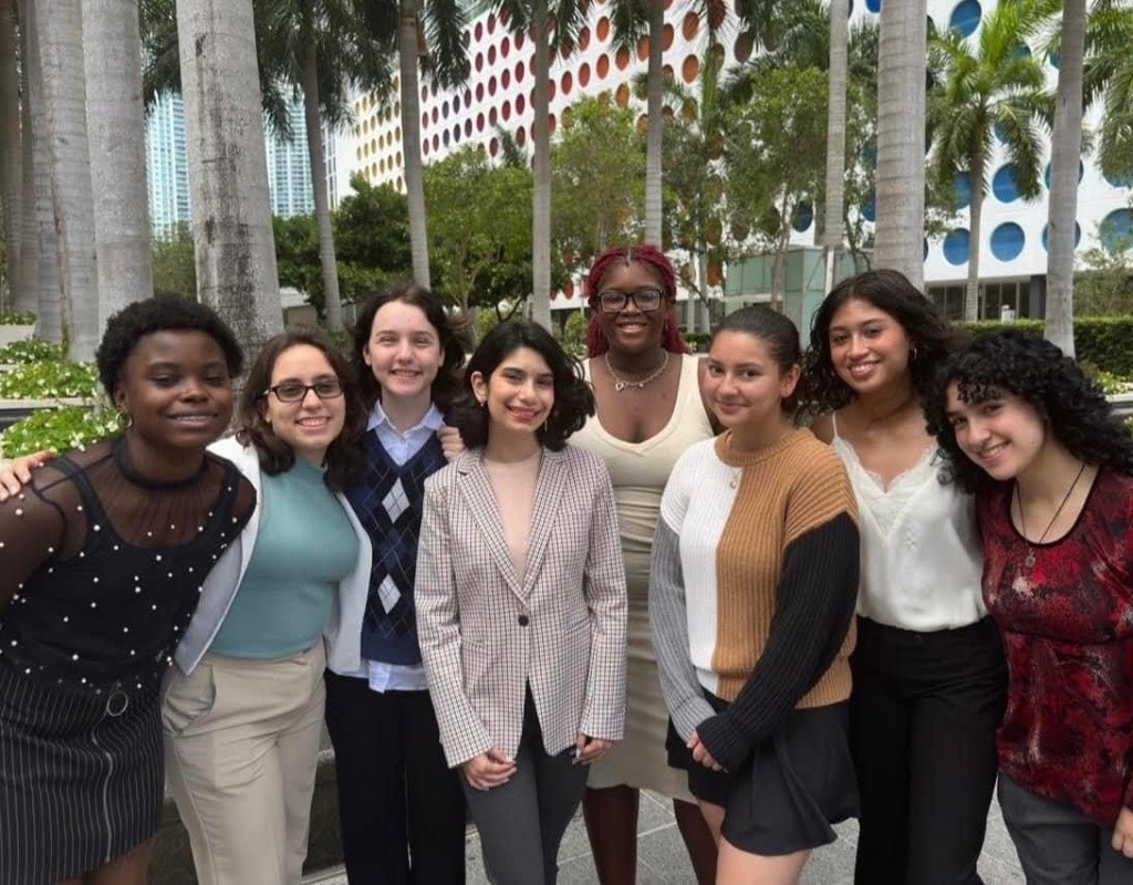 Posse scholars pose together, palm trees in the background.