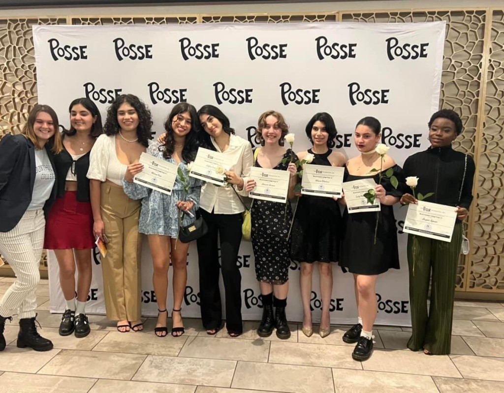 Posse scholars pose in front of Posse Foundation backdrop holding certificates.