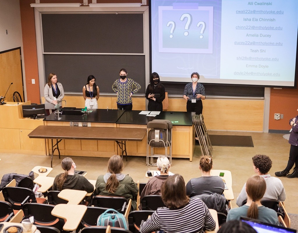 A group of student presenters in front of a lecture hall audience during LEAP Symposium 2022