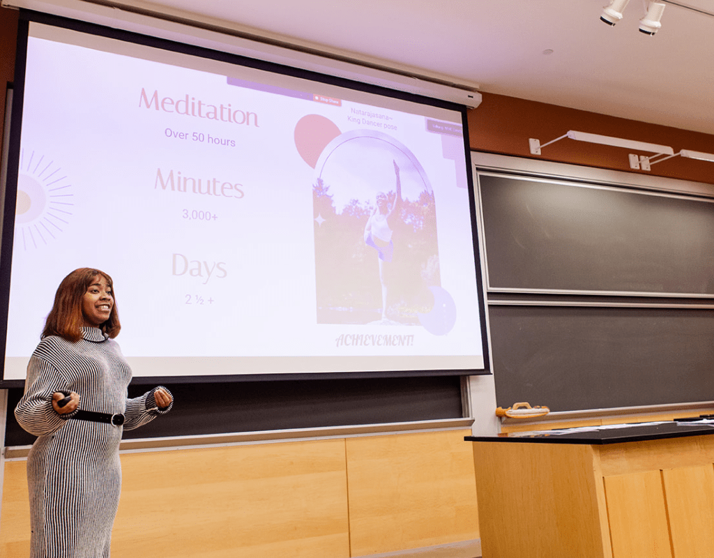 A student presenting in front of a screen during LEAP Symposium 2022
