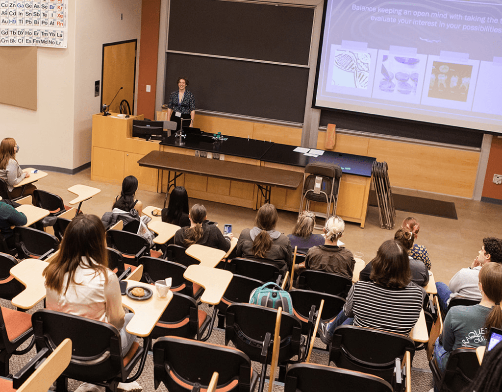 A student presents in front of a lecture hall audience during LEAP Symposium 2022