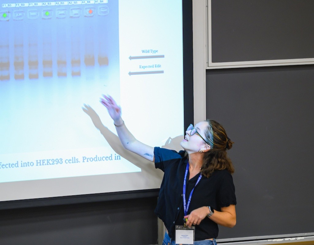 A student points out their presentation, LEAP Symposium 2025