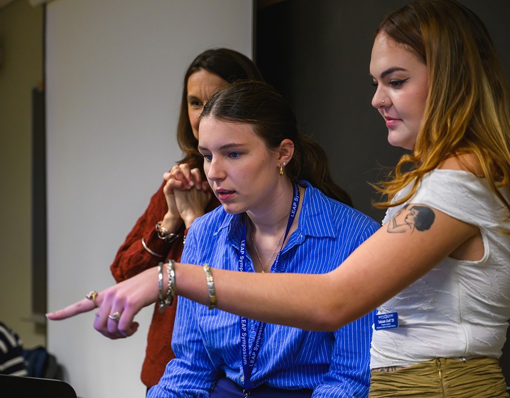 Students gathered, looking at computer screen, LEAP 2024, Mount Holyoke College