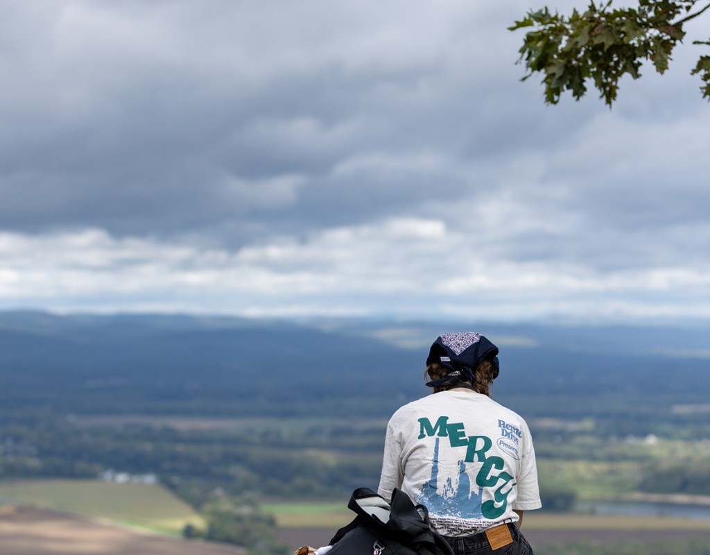 A student sits atop a rock on the summit of Mt. Holyoke.
