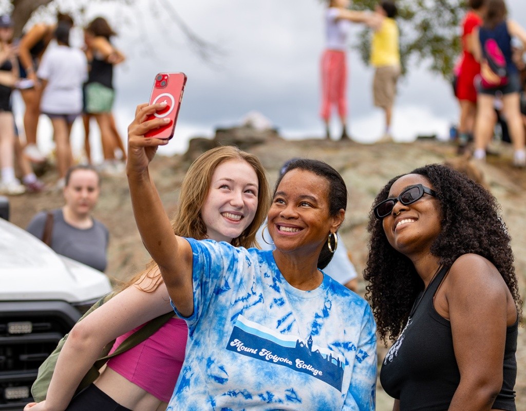 President Holley takes a selfie with students atop the summit on Mt. Holyoke.