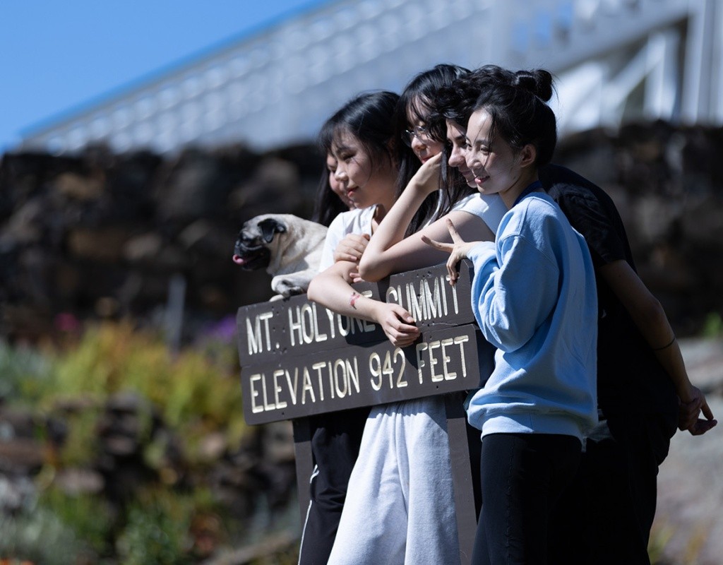 Students gather behind the Mt. Holyoke summit sign