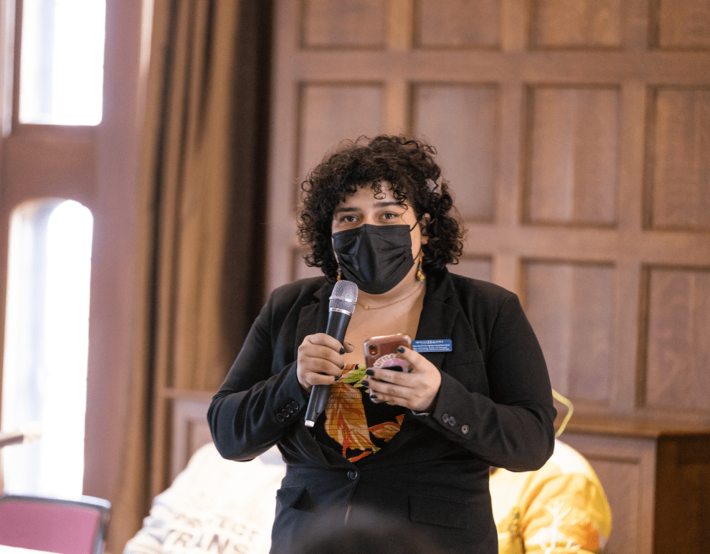 A member of the audience standing to ask a question during a session of the 2023 BOOM! Learning Symposium