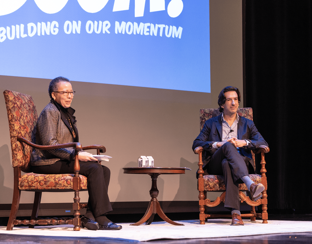Dr. Beverly Daniel Tatum and Dr. Geoff Cohen seated onstage for the opening of the 2023 Boom! Learning Symposium
