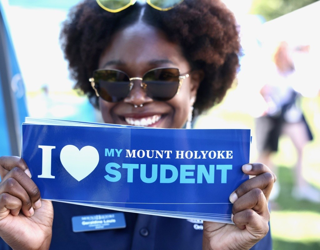Parent holding bumper sticker that reads "I love my Mount Holyoke student"