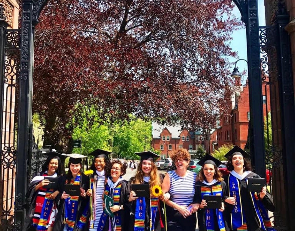 Posse students in graduation regalia pose by the Gates.