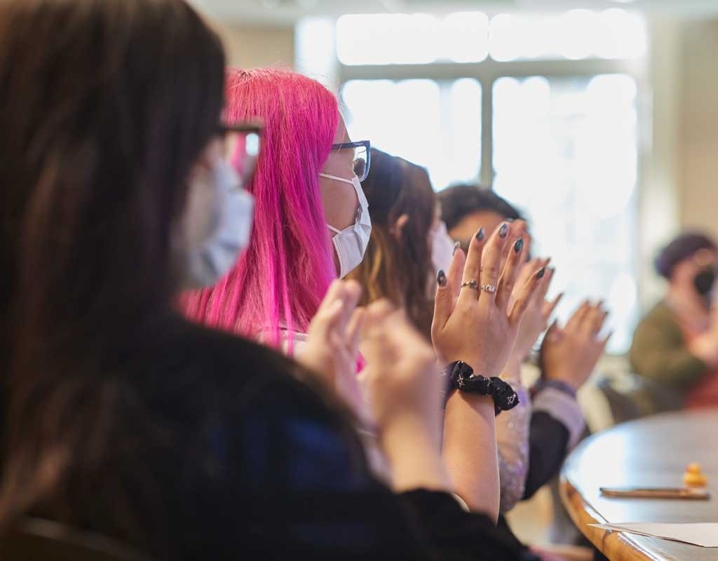 Students clapping during a presentation at Senior Symposium