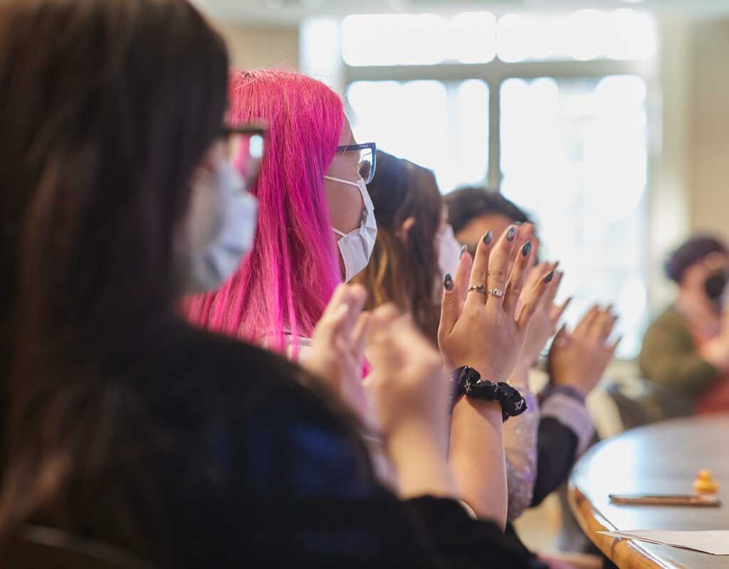 Students clapping during a presentation at Senior Symposium
