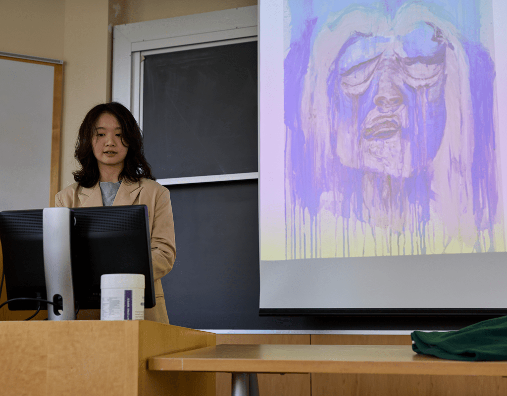 A student standing behind a podium while presenting during Senior Symposium 2023