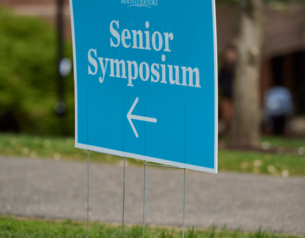 A lawn sign advertising Senior Symposium