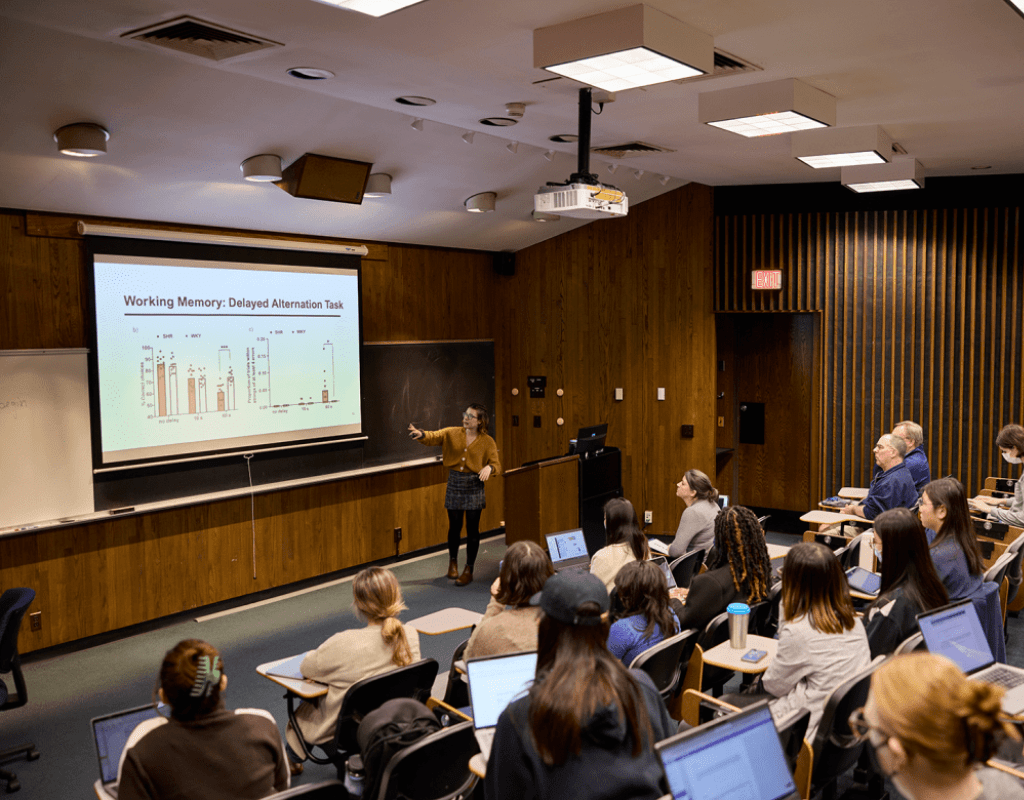 Presenter pointing at a screen presentation during Senior Symposium 2023