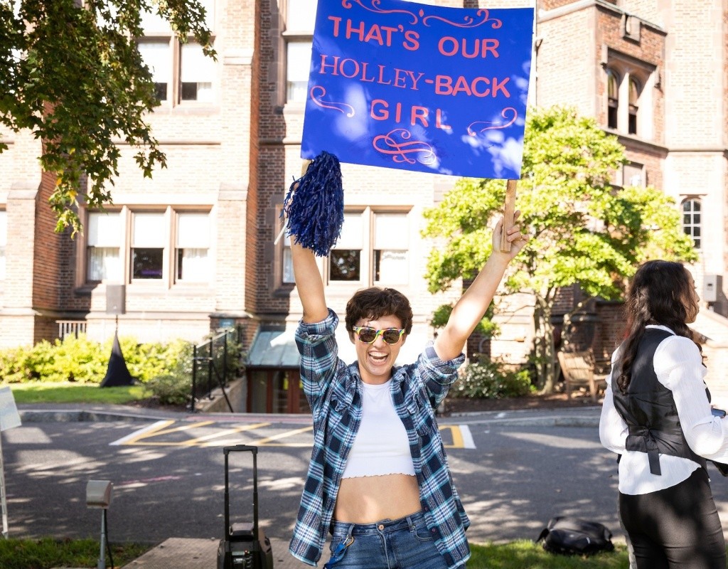 Student on Pageant Green holding a sign that reads - &quot;That's our Holley Back girl&quot;