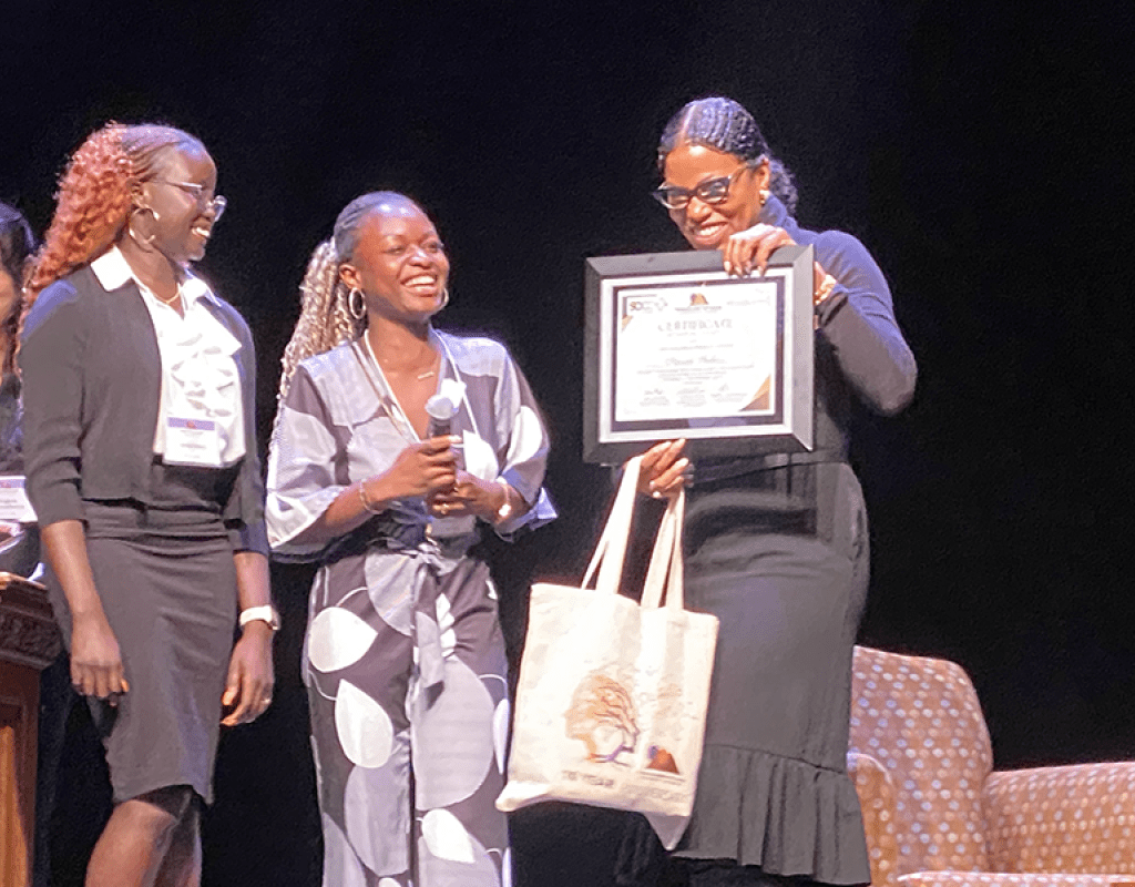 TOCLC attendees present Ilyasah Shabazz with a certificate.