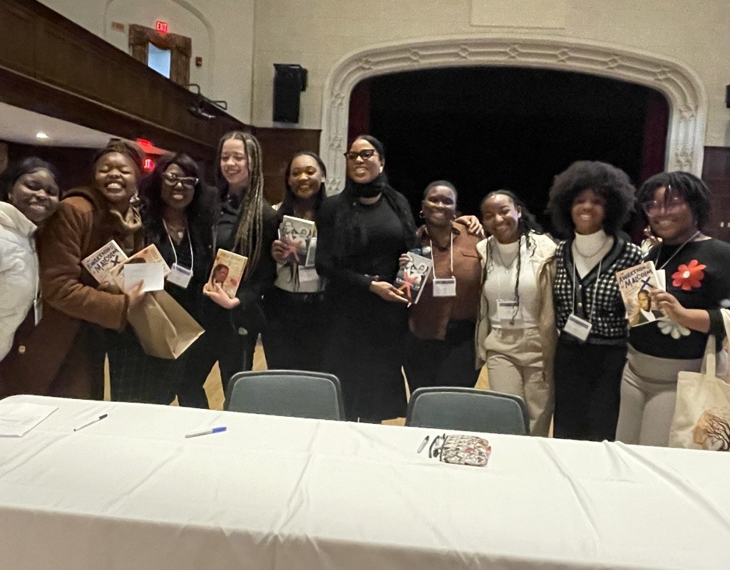 TOCLC attendees pose together with Ilyasah Shabazz and copies of her book.