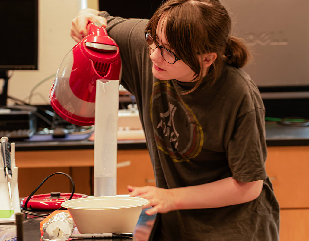 MHC student attending the QIC event pours the ingredients carefully.