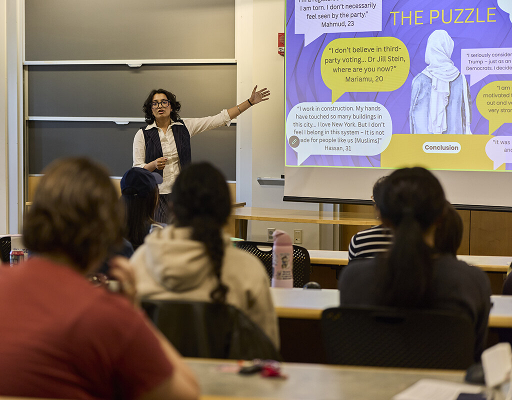 Student points to their research while presenting, Senior Symposium 2026.