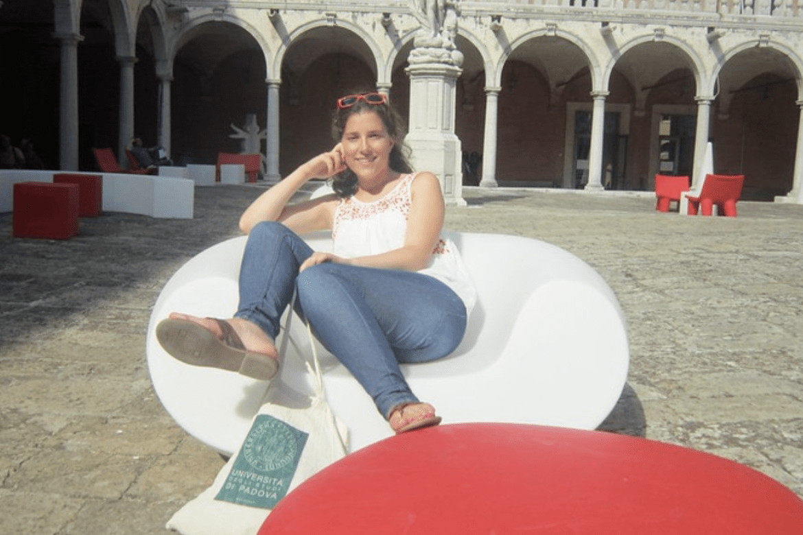 Kathryn Higgins '12 lounging in a courtyard in Italy