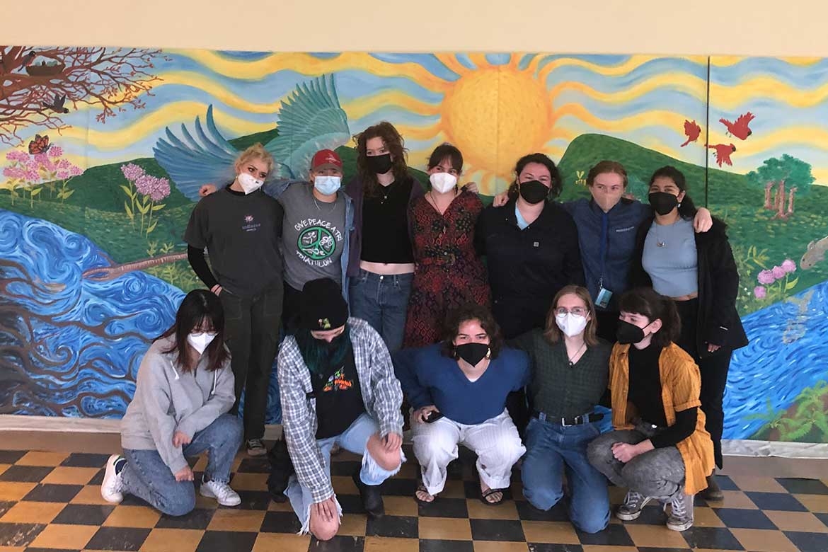 The group of students who worked on the Public Art mural, posing in front of the completed mural