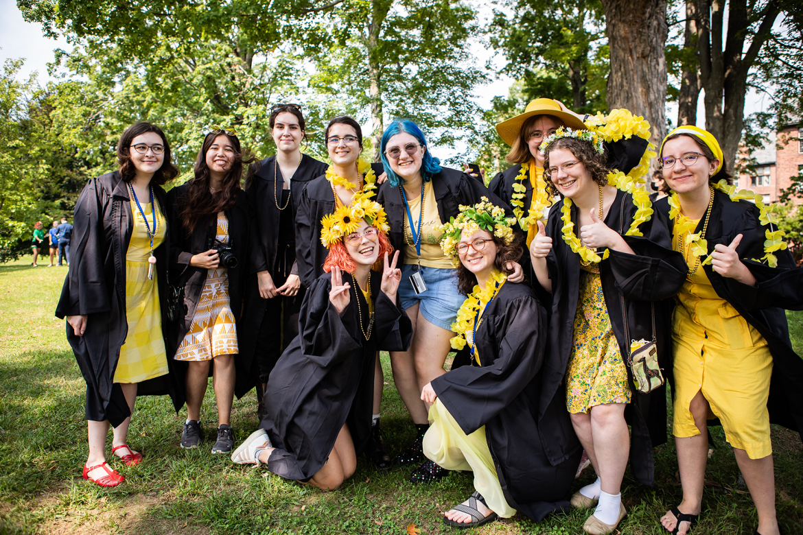 A group of seniors in their graduation robes with yellow clothing underneath ready for Convocation 2022