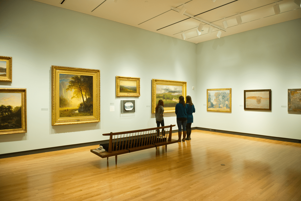 Three students looking at art in a gallery.