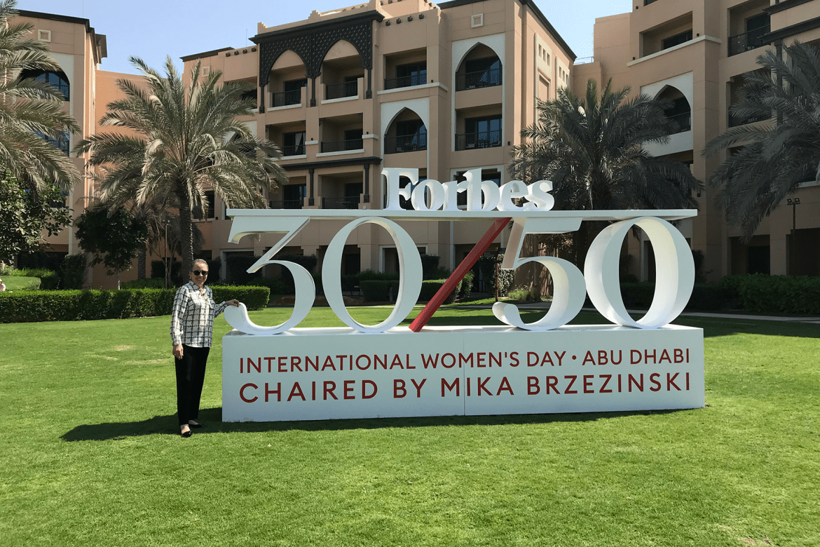 Interim President Beverly Daniel Tatum stands near a sign for International Women's Day in Abu Dhabi