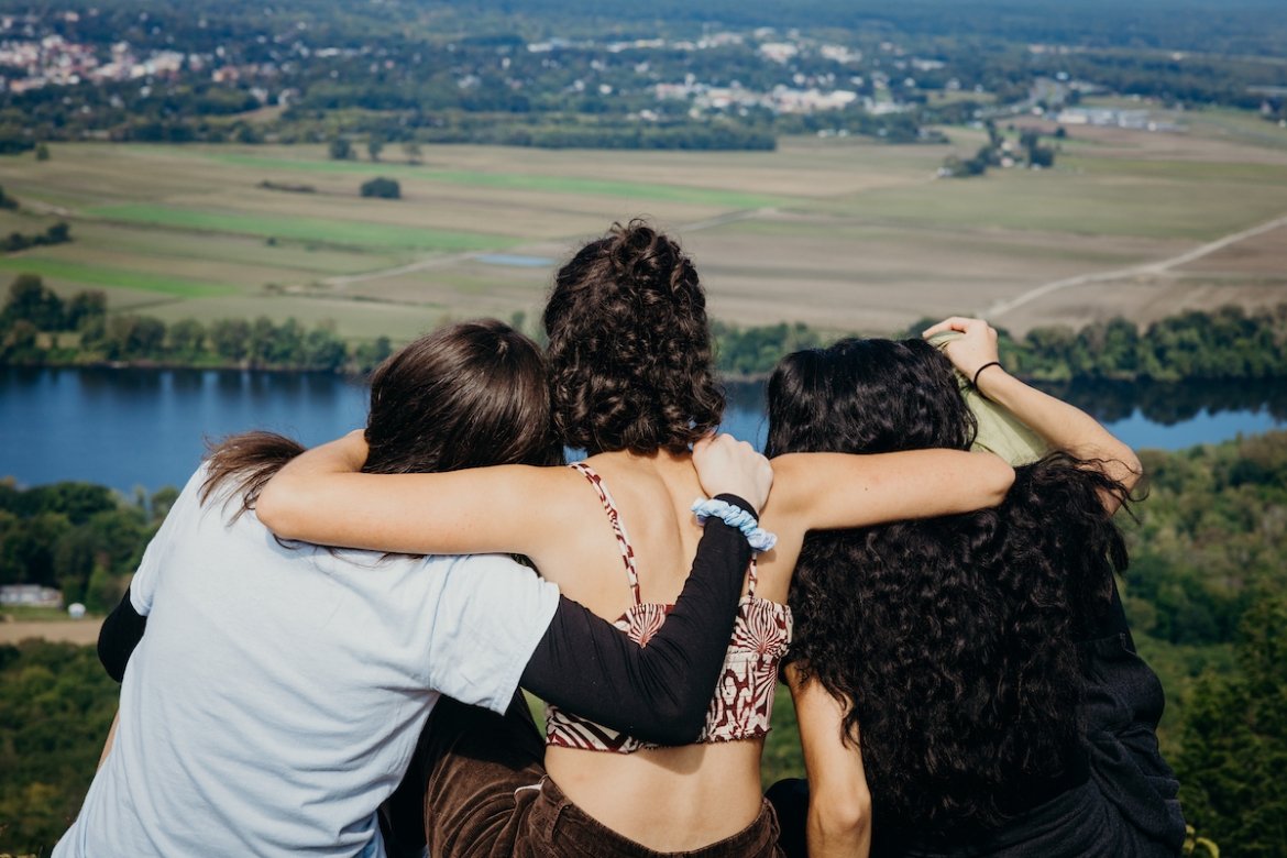 Three students looking out over the valley from the top of the mountain on Mountain Day