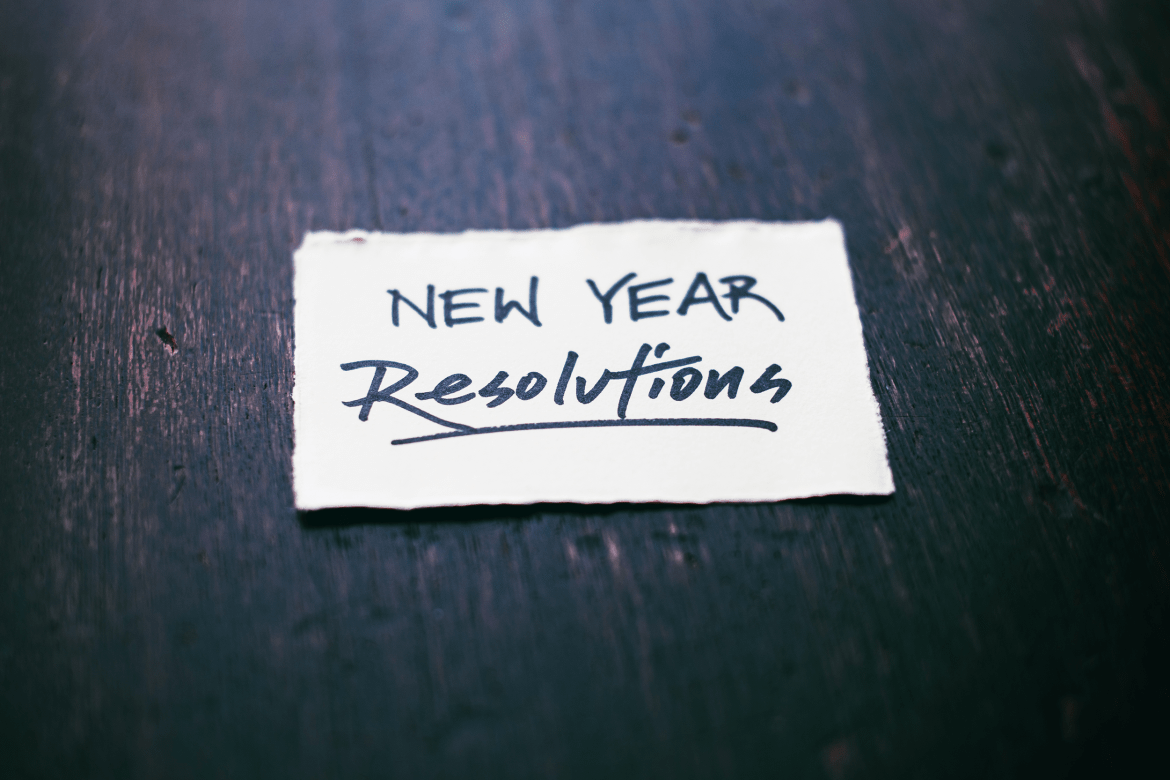 A piece of paper that says “New Year Resolutions.” Photo by Tim Mossholder on Unsplash.