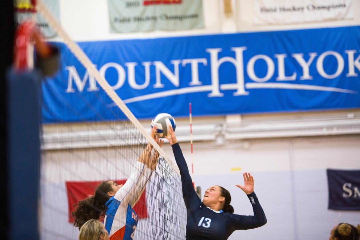 MHC volleyball team player puts the ball over the net. Photo by Ryan Donnell, in 2017.