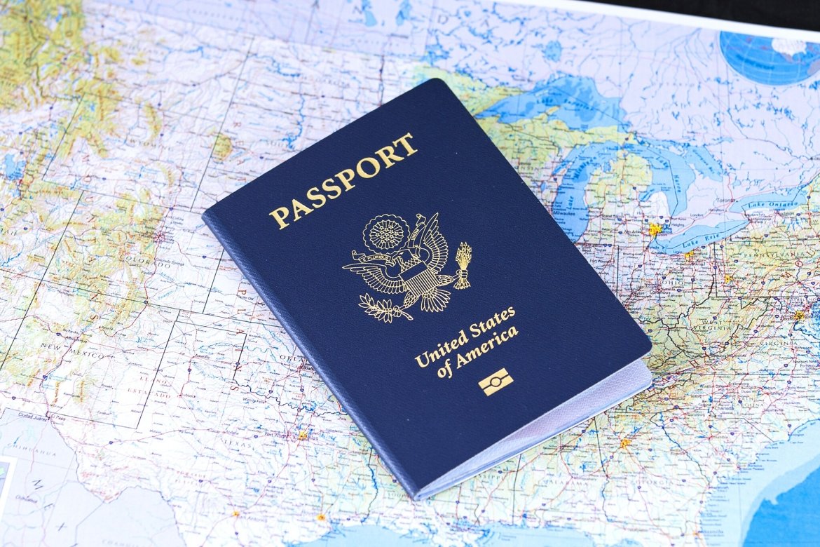 A blue American passport lies atop a map of the world.